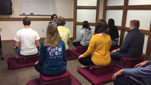 Students meditate together in class, new meditation group